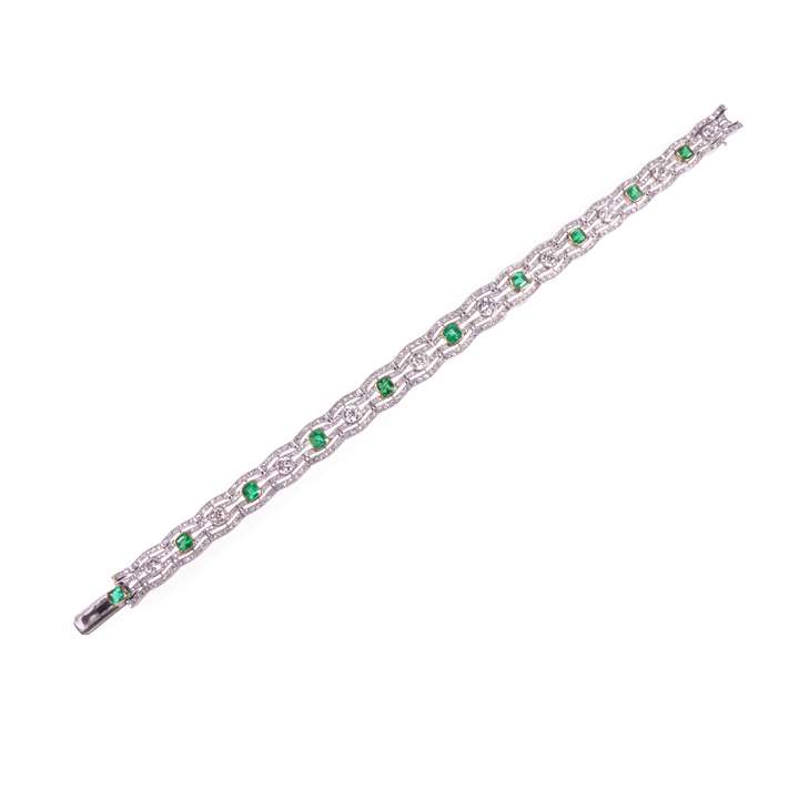 Early 20th century diamond and emerald bracelet of openwork scroll line design